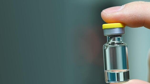 Ein Mitarbeiter hält im Werk des Impfstoffherstellers IDT Biologika in Dessau-Roßlau eine Ampulle, in die später der Impfstoff abgefüllt wird.  Foto: Hendrik Schmidt/dpa