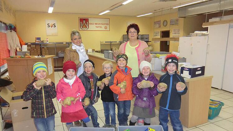 Die Vorschulkinder vom Kinderhaus Pusteblumen brachten ihre gesammelten Lebensmittel und die größten Langenleitner Kartoffeln zur Tafel nach Bad Neustadt. Mit auf dem Foto sind Kinderhausleiterin Michaela Nöth (links) und die Vorsitzende der Tafel Romy Straub (rechts). Foto: Marion Eckert