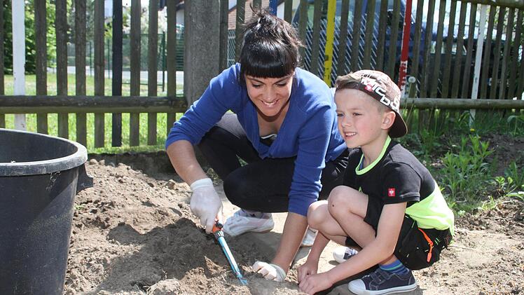 Julia Derfler lie&szlig; sich von ihrem Sohn Luis (7) gerne &uuml;berreden, bei der Instandsetzung des Schulgartens mitzuwirken. Foto: Sonny Adam