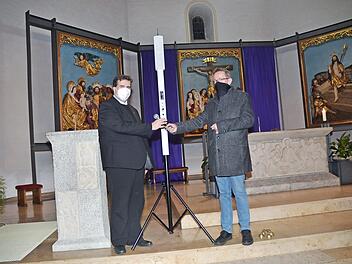 Kirchenpfleger Mathias Beetz überreicht das Mikrofon der neuen Beschallungsanlage in der St.-Bartholomäus-Kirche an Pfarrer Detlef Pötzl, der sie in Betrieb nahm.  Foto: K.-H. Hofmann
