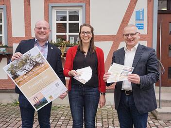 Die Kreuzbergtour steht zur Wahl als Deutschlands schönster Wanderweg. Bürgermeister Georg Seiffert (links), Hannah Wilm von der Rhön GmbH und Tourismusreferent Gerhard Nägler präsentieren die eigens für die Abstimmung gefertigten Plakate und Werbekarten. Foto: Marion Eckert