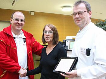 Jetzt kann Monika John wieder lachen. Sie dankt ihren Lebensrettern Christian Glaser (l.) und Chefarzt Eberhard Kuon. Ein Herzkranzgefäß (schwarzer Pfeil) war verstopft und führte zum Infarkt. Foto: Hofbauer