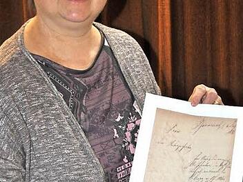 Stolz zeigt Vorsitzende Andrea Werner vom Verein für Gartenbau und Landschaftspflege bei der Jahresversammlung am Freitag die Gründungsurkunde der Pfarrweisacher Gartenbauer vom 15. August 1881. Volker Kuhn hatte ihr die Urkunde erst wenige Stunden zuvor überreicht, nachdem er die Schriftstücke im Rahmen von Archivarbeiten gefunden hatte.  Foto: Simon Albrecht