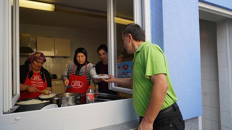 Birsel Birinci, Omür Torun und Aycan Birinci (von links) beginnen, das Essen auszugeben, das die Frauen im Laufe des Vormittags gekocht hatten.