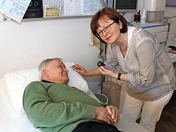 Gabriele Brütting erklärt einem Patienten das Schlafkissen.