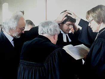 Das Handauflegen ist das zentrale Segenszeichen der Ordination. Die religiöse Geste wurde Niels Hönerlage (2. von rechts) von Gisela Bornowski, Pfarrer Gerd Kirchner und Vater Dirk Hönerlage (links) zuteil. Foto: Rolf Pralle