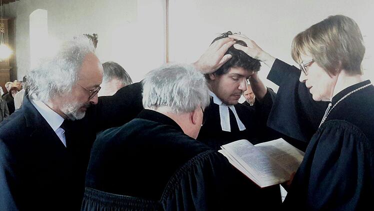 Das Handauflegen ist das zentrale Segenszeichen der Ordination. Die religiöse Geste wurde Niels Hönerlage (2. von rechts) von Gisela Bornowski, Pfarrer Gerd Kirchner und Vater Dirk Hönerlage (links) zuteil. Foto: Rolf Pralle
