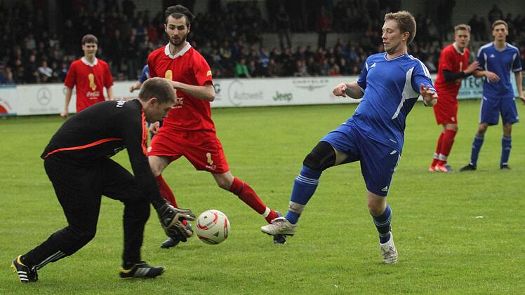 TSV-Schlussmann Hendrik Ruß holt dem Sylbacher Angreifer (blaues Trikot) den Ball noch vom Fuß. Dazwischen TSV-Stopper Dominique Kandler, der wegen Gelb-Roter Karte später das Feld verlassen musste.
