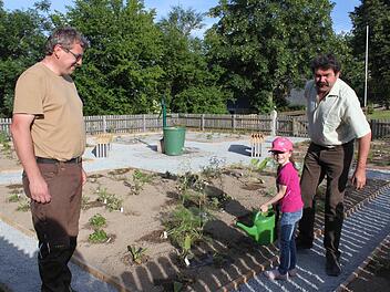 Reiner Wachter (links) und Josef Baier sind glücklich, dass der Garten rechtzeitig zum Bürgerfest fertiggeworden ist. Eva Wachter hilft beim Gießen.  Foto: Veronika Schadeck