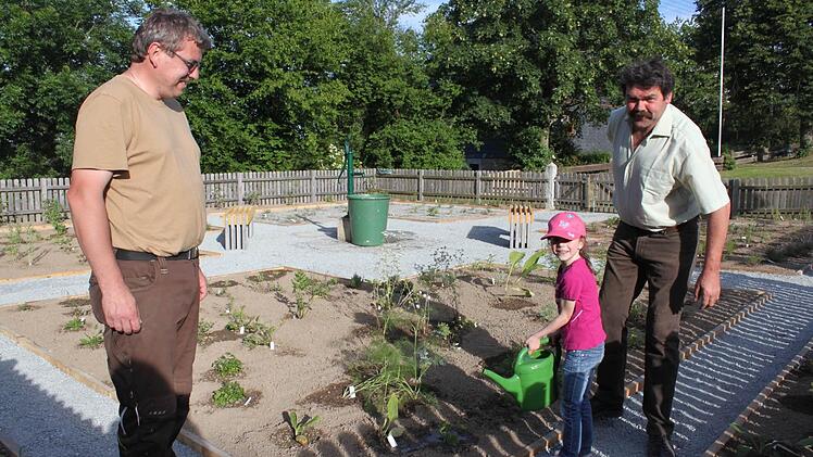 Reiner Wachter (links) und Josef Baier sind glücklich, dass der Garten rechtzeitig zum Bürgerfest fertiggeworden ist. Eva Wachter hilft beim Gießen.  Foto: Veronika Schadeck