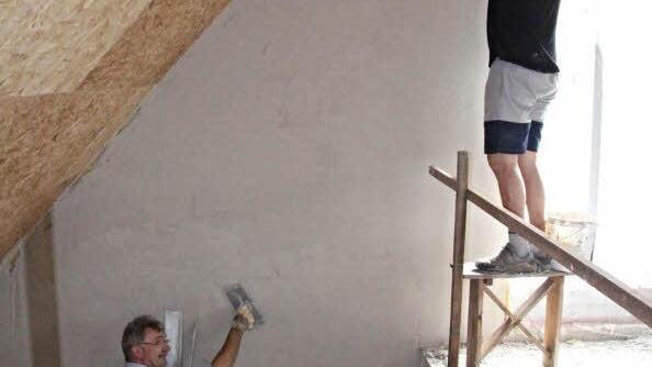 Bürgermeister Helmut Dietz (unten) und Michael Fromm (oben) beim Glätten des Putzes.  Foto: Helmut Will