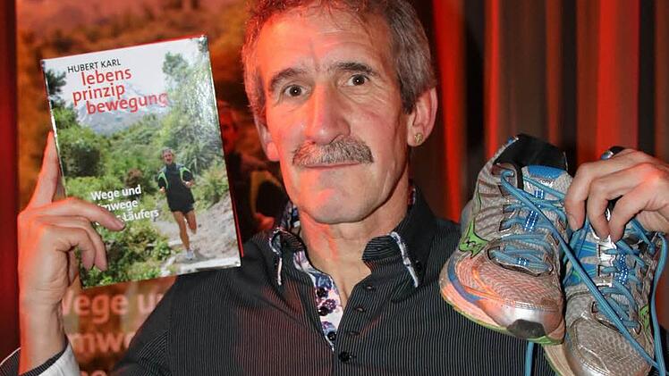 Hubert Karl, Ultraläufer und Autor, mit Buch und Laufschuhen