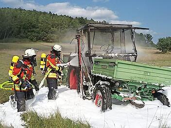 Mittels Schaumangriff unter schwerem Atemschutz wurde der Traktor abschließend komplett gelöscht.  Foto: Feuerwehr Heroldsbach/Thurn