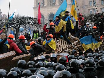 Demonstranten und Polizei stehen sich an einer Barrikade in Kiew gegenüber. Foto: Anatoli Malzew