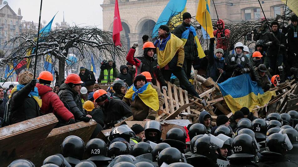 Demonstranten und Polizei stehen sich an einer Barrikade in Kiew gegenüber. Foto: Anatoli Malzew