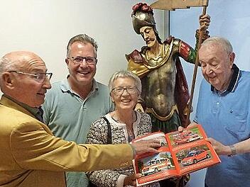 Ehrenmitglied und Alt-Bürgermeister Hans Lang (l.) und seine Frau Helga sowie Vorsitzender Thomas Geiger lassen sich von Karl-Heinz Schalk (r.) den Inhalt des neuen Buchs erläutern. Im Hintergrund wacht St. Florian mit Argusaugen darüber.