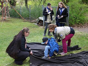 Zeltplanen zusammenzuknüpfen, ist gar nicht so einfach. Stammesführerin Yvonne Sturmat (rechts) erklärt ist den Buben, bevor sie es selber versuchen müssen. Foto: Dieter Britz