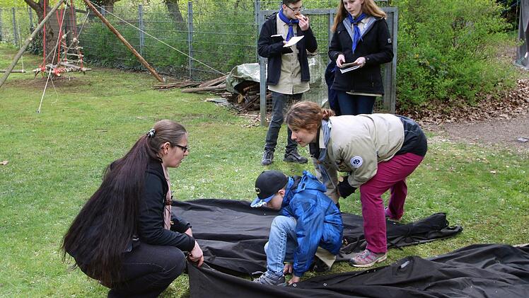 Zeltplanen zusammenzuknüpfen, ist gar nicht so einfach. Stammesführerin Yvonne Sturmat (rechts) erklärt ist den Buben, bevor sie es selber versuchen müssen. Foto: Dieter Britz