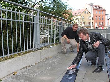 Der Künstler Harald Winter poliert sein Kleemann-Kunstwerk im Forchheimer Kleemann-Weg. Im Hintergrund der Bildhauer-Meister Sebastian Bertholdt, der Winters Werk handwerklich umsetzte. Foto: Roepert