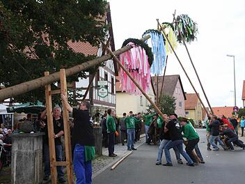 Der Kirchweihbaum wird in Wiesenthau besonders farbenprächtig geschmückt. Beim Hochstemmen ist deshalb viel Kraft notwendig.  Foto: Franz Galster