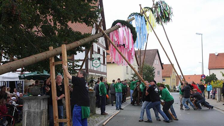 Der Kirchweihbaum wird in Wiesenthau besonders farbenprächtig geschmückt. Beim Hochstemmen ist deshalb viel Kraft notwendig.  Foto: Franz Galster