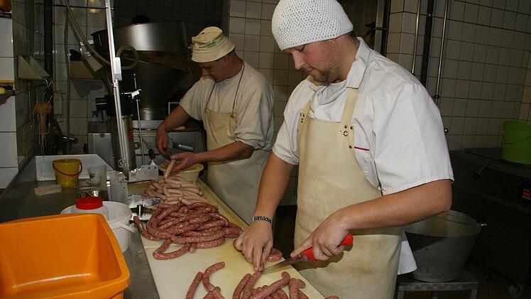 Hand in Hand arbeiten Frank Neundörfer und sein Sohn Johannes (vorne), der frischgebackene Metzgermeister, der den Kirchaicher Betrieb in fünfter Generation weiterführen wird. Foto: Sabine Weinbeer
