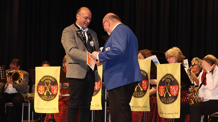 Der Dirigent des Musikvereins Höfles-Vogtendorf Jürgen Fischer gratulierte dem Initiator des Abends, Walter Wich-Herrlein.  Foto: Michael Wunder