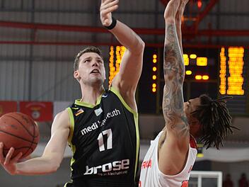 Bayreuths Lukas Meisner (links) setzt sich gegen Lissabons Arnette Hallman durch. Meisner war beim Eimzug ins Europapokal-Viertelfinale mit 17 Punkten bester Medi-Werfer.  Foto: Peter Mularczyk