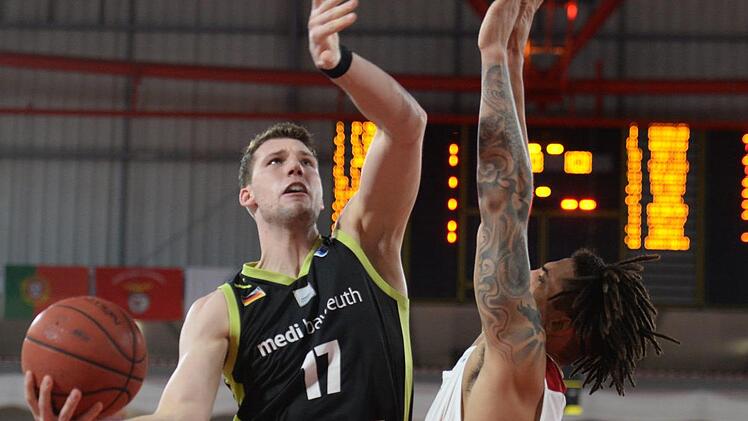 Bayreuths Lukas Meisner (links) setzt sich gegen Lissabons Arnette Hallman durch. Meisner war beim Eimzug ins Europapokal-Viertelfinale mit 17 Punkten bester Medi-Werfer.  Foto: Peter Mularczyk