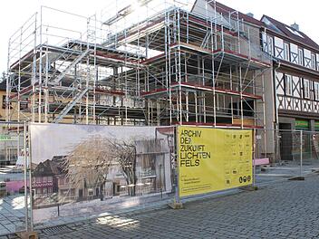 Die Baustelle auf dem Lichtenfelser Marktplatz. Ein gelbes Transparent benennt das Vorhaben, links daneben eine Darstellung, wie es einmal aussehen soll. Markant daran die aus Metall gefertigten Bäume.Popp