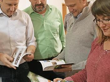 Die Gemeinderäte schauen sich Beispielbroschüren an. Foto: hu