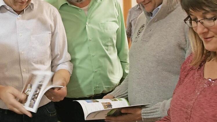 Die Gemeinderäte schauen sich Beispielbroschüren an. Foto: hu
