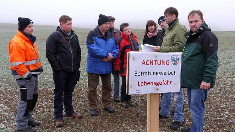 Betreten verboten: Robert Prell, Dietmar Schnapp, Theo Böhmer, Heinrich Böhmer, Cornelia Meixner, Manuela Krauß, Christian Weyer, Jürgen Finkel und Wolfgang Hornung (von links) wehren sich dagegen, dass sie die Kosten für die Kampfmittelräumung auf ihren Ackerflächen zwischen Unterbrunn und Rattelsdorf übernehmen sollen. Foto: Berthold Köhler