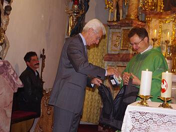 Kirchenpfleger Roland Pompe beschenkte Pater Jan Poja zum Abschied mit einem Rucksack und einer Notfall-Box.   Fotos: Schülein
