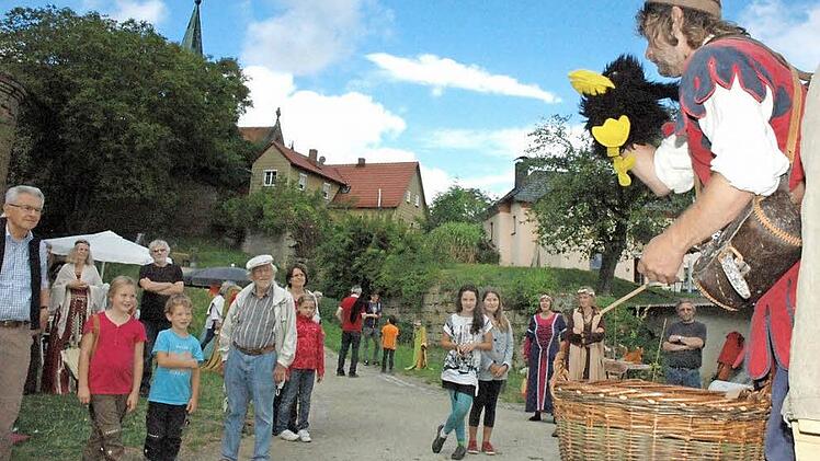 Der Spielmann "Schabernackrakeel" und sein Rabe unterhielten die Kinder im Burggraben. Fotos: Gerhard Schmidt