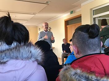 Der Memmelsdorfer Bürgermeister Gerd Schneider  spricht mit  Mietern aus dem Mehrfamilienhaus in der Lichteneiche, in dem es diese Woche brannte.  Foto: Anette Schreiber