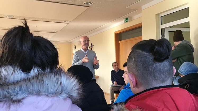 Der Memmelsdorfer Bürgermeister Gerd Schneider  spricht mit  Mietern aus dem Mehrfamilienhaus in der Lichteneiche, in dem es diese Woche brannte.  Foto: Anette Schreiber
