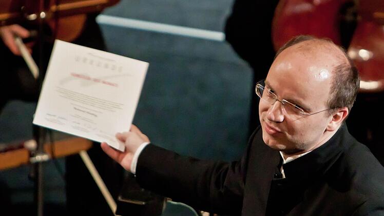 Coburgs Generalmusikdirektor Roland Kluttig mit der Urkunde ,Künstler des Monats' der Metropolregion Nürnberg. Die Auszeichnung erhielt er im Rahmen eines Sinfoniekonzert im Landestheater.Fotos: Jochen Berger