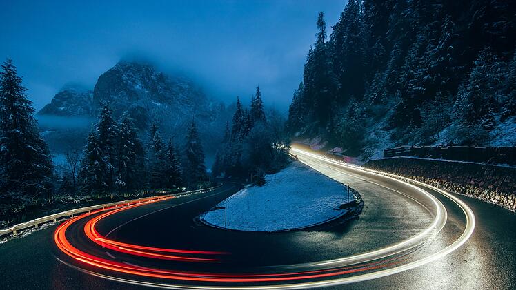 Reise, Winterreifen - Night traffic lights on a road in snowy Italian Alps, South Tyrol, Italy