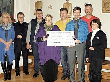 Die dritte Station "Jesus nimmt das Kreuz auf seine Schultern" des geschnitzten Kreuzweges (Hintergrund), der nun als Leihgabe in der Kapelle des Caritas-Altenheims hängt - davor die Spendenübergabe  Foto: Deuerling