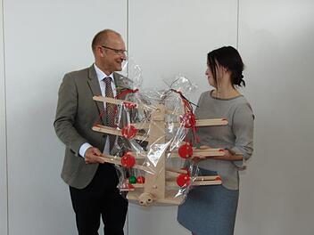 Peter Ehmann. Leiter des Caritasverbands,  überreichte beio der Einweihung des Familienstützpunkts von der Dr.-Bosch-Stiftung ein Spiel als Geschenk an Sozialpädagogin Evelyn Lacken.Petra Malbrich