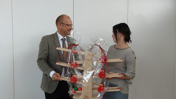 Peter Ehmann. Leiter des Caritasverbands,  überreichte beio der Einweihung des Familienstützpunkts von der Dr.-Bosch-Stiftung ein Spiel als Geschenk an Sozialpädagogin Evelyn Lacken.Petra Malbrich