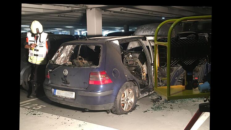 Der blaue Golf, der in der Tiefgarage in Brand geraten war, hat nur noch Schrottwert. Foto: Stephan Tiroch