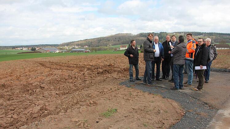 Der Acker (im Hintergrund) wird für das künftige Gewerbegebiet mit dem Erdaushub der Rehbergkuppe aufgefüllt.