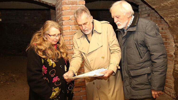 Diplom-Ingenieur Thom Roessler zeigt Pfarrerin Beate Stark (links) und Peter Schuhmann einen Plan, worauf die zehn großen Keller, eingezeichnet sind. Foto: Michael Stelzner