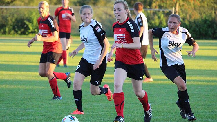 Hochmotiviert und nicht zu stoppen: Sissy Martin von der DJK Schondra (Mitte, rotes Trikot) läuft der Hammelburgerin Eva Schmitt (links, weißes Trikot) mit dem Ball davon und belohnt sich für den beschwingten Auftritt mit dem Tor zum 7:0.  Foto: Sebastian Schmitt