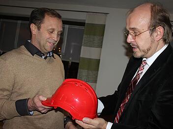 Der SPD-Kreisvorsitzende, Ralf Pohl (r.) überreichte Thomas Friedlein einen roten Helm. Der soll ihn von allen Widrigkeiten schützen. Foto: Schadeck