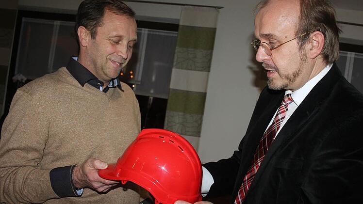 Der SPD-Kreisvorsitzende, Ralf Pohl (r.) überreichte Thomas Friedlein einen roten Helm. Der soll ihn von allen Widrigkeiten schützen. Foto: Schadeck