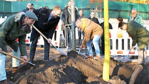 Anwohner halfen Christoph Kintopp, Abteilungsleiter Stadtgr&uuml;n der Stadt Erlangen (l.) und Oberb&uuml;rgermeister Florian Janik (2. v. l.) beim Pflanzen des Baumes. Foto: Stadt Erlangen
