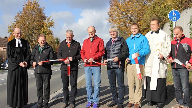 Der Rad- und Gehweg ist offiziell eröffnet. Am Samstag setzten den symbolischen Scherenschnitt (von links): Pfarrer Martin Popp-Posekardt, ein Vertreter der Baufirma, Bürgermeister Günter Pfeiffer, Ermershausen, Landrat Wilhelm Schneider, Baudirektor Manfred Rott, Bürgermeister Wolfram Thein, Maroldsweisach, Pater Michael und 2. Bürgermeister Harald Deringer, Maroldsweisach. Foto: Helmut Will